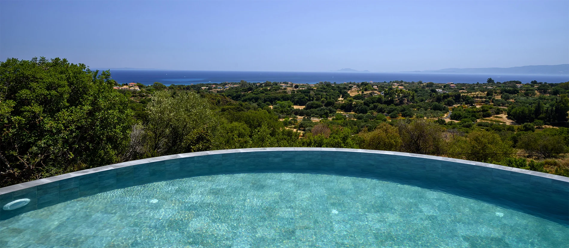 Villa with Large infinity pool with sun loungers, umbrellas, and outdoor seating