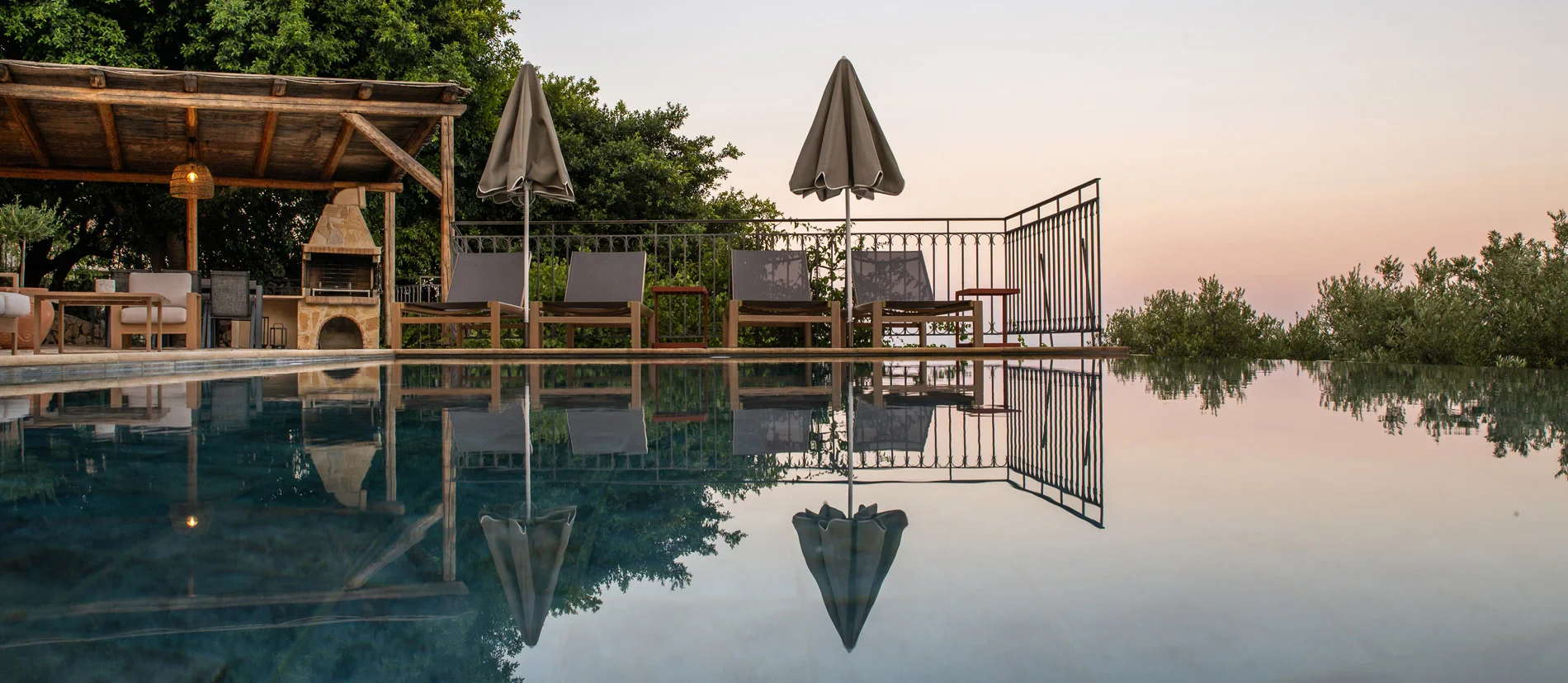 Villa with Large infinity pool with sun loungers, umbrellas, and outdoor seating